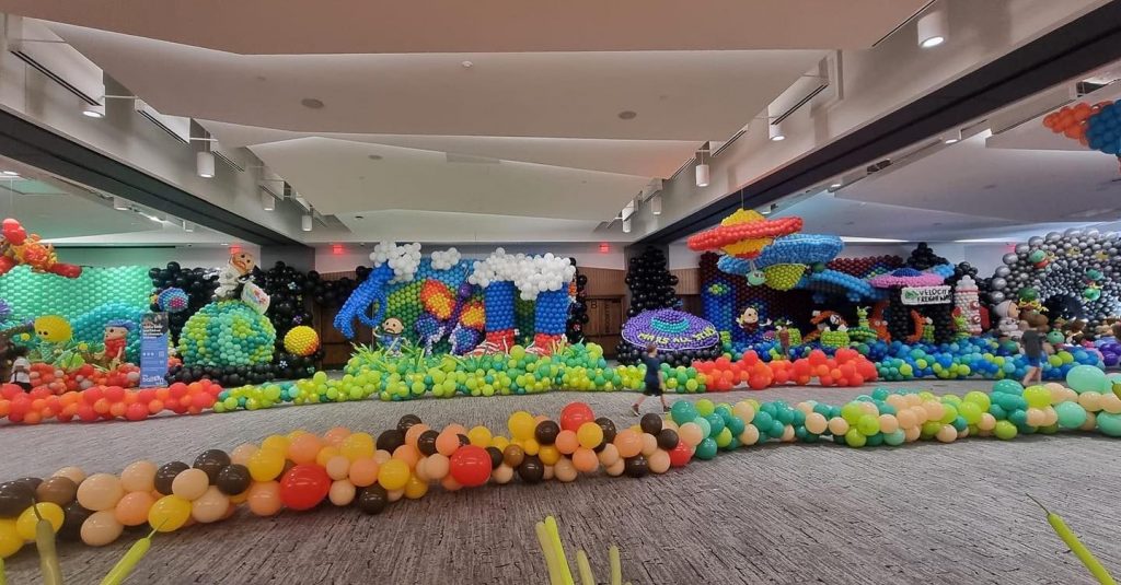 A panoramic shot of one side of @thebigballoonbuild 
Plant World, Giant World, UFO SPACESHIPS, Post Office and Black Hole!
#BigBalloonBuild
#BBBColorado
#BalloonArtbyMerryMakers
#PremiumConwin
#GemarBalloons
#LifeStoriesWeld
#AimsCC