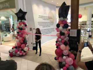 Grand opening ribbon cutting balloon columns retail store in mall
