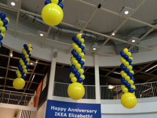 Ikea anniversary balloon columns suspended from ceiling retail store lobby